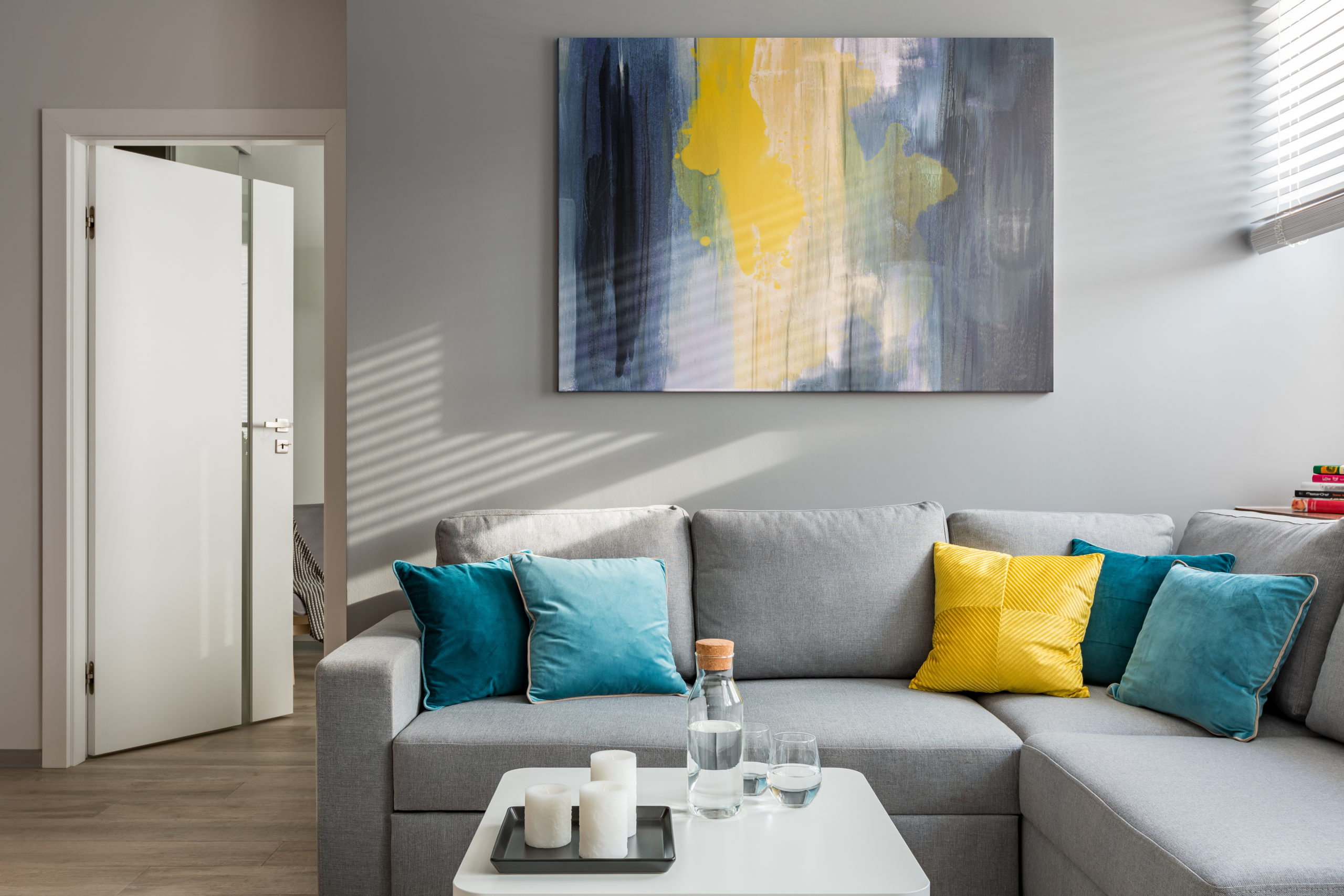 Living room with corner sofa, colorful cushions and white coffee table