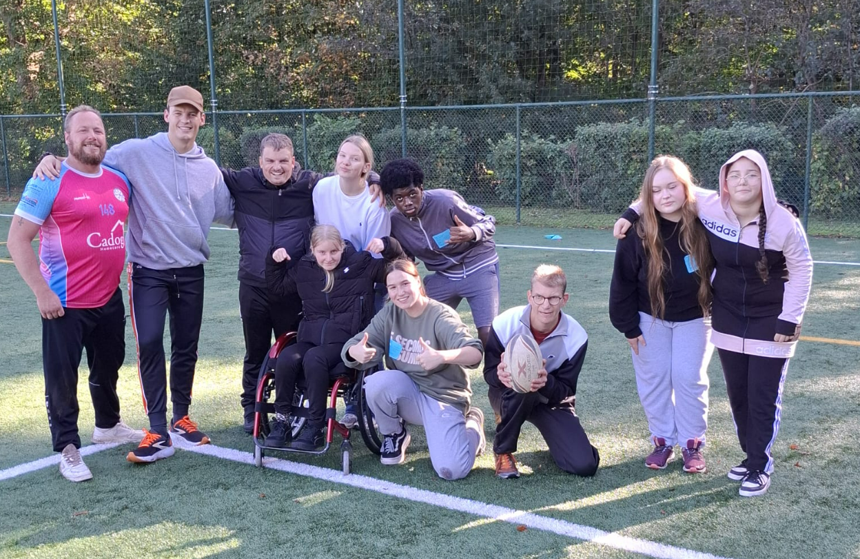 G-sporters en begeleiders poseren samen tijdens de rugbyworkshop op de inclusieve G-sportdag in Brasschaat.