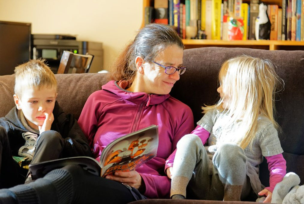 A woman and two children enjoy reading together