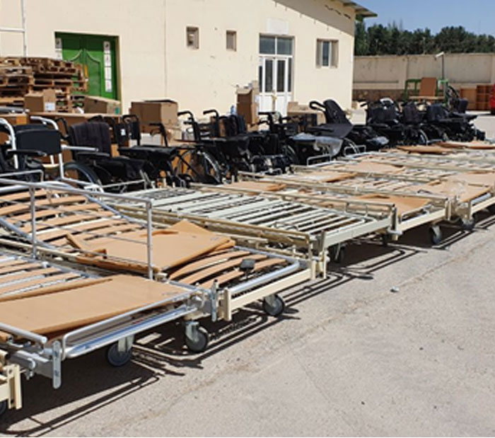Hospital beds, wheelchairs, and medical equipment prepared for shipment from Denmark to Badghis Province, Afghanistan, as part of a health support project implemented by Rebuild Aid Forening with support from Genbrug til Syd.