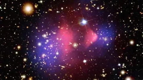 Un'immagine composita del Bullet Cluster, una coppia di ammassi di galassie molto studiati che si sono scontrati frontalmente. Uno è passato attraverso l'altro, come un proiettile che attraversa una mela, e si pensa che mostri chiari segni di materia oscura (blu) separata dai gas caldi (rosa). (Credito immagine: raggi X: NASA/ CXC/ CfA/ M.Markevitch, mappa ottica e con lenti: NASA/STScI, Magellan/ U.Arizona/ D.Clowe, mappa con lenti: ESO/WFI)