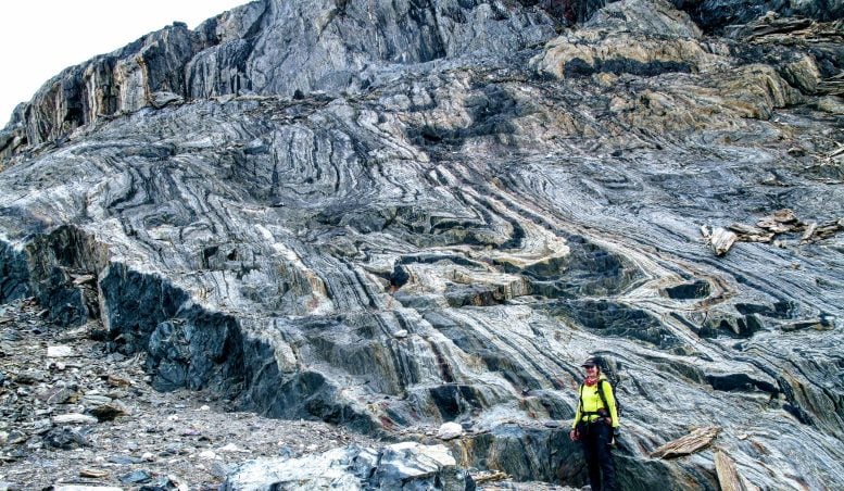 La coautrice dello studio Athena Eyster si trova di fronte a un'ampia esposizione di formazione di ferro a bande, il deposito ricco di ferro da cui venivano estratti antichi segnali di campo magnetico. Credito: Claire Nichols