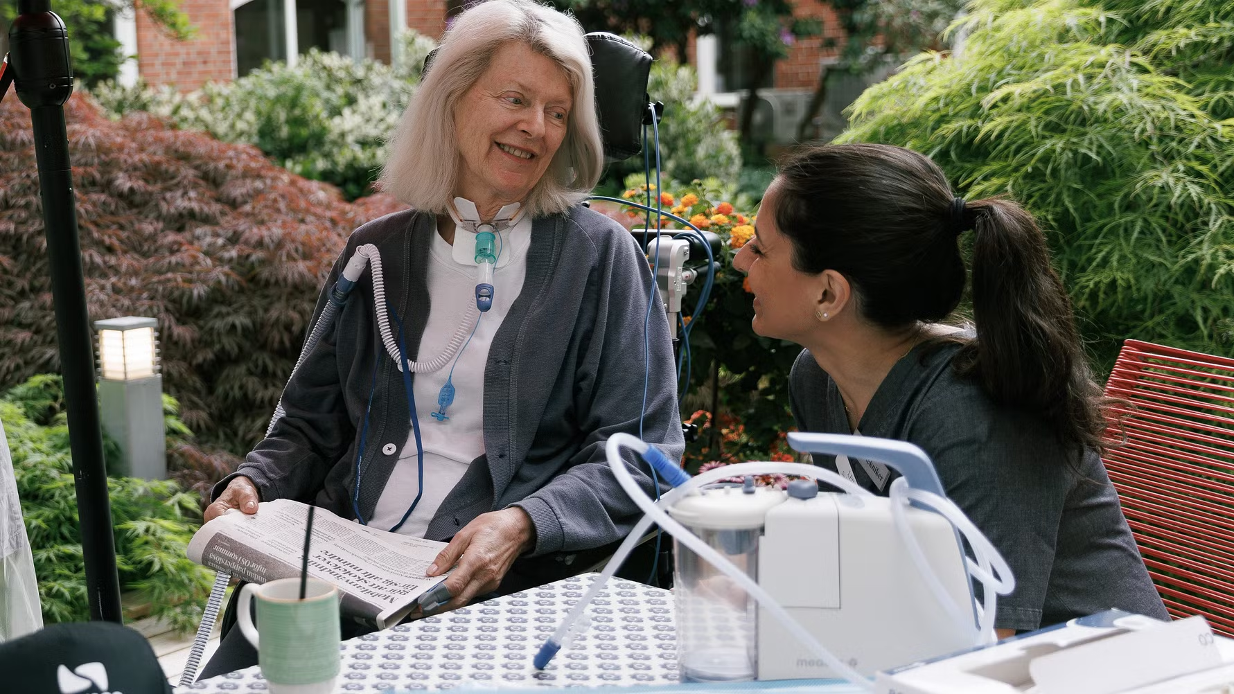 Patient med individuell assistent i innergård på Remeo.