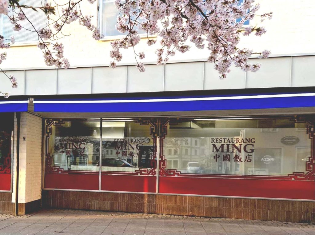 Photo on the outside of Restaurant Ming, flowering cherry tree in the foreground.