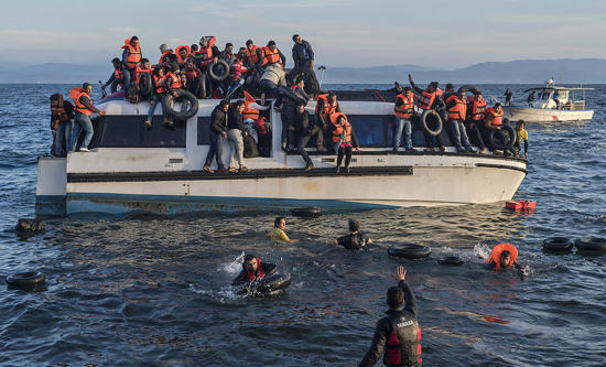 Syrian and Iraqi refugees arrive from Turkey to Skala Sykamias, Lesbos island, Greece. Volunteers (life rescue team - with yellow-red clothes) from the Spanish NGO Proactiva Open Arms help the refugees. (Photo: Ggiga / CC BY-SA 4.0)