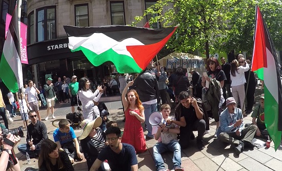 RCG and supporters hold a sit-down protest in front of a Glasgow Friends of Israel stall