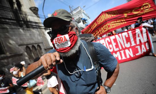 A protester with a microphone and mask reading 'fora Bolsonaro' (photo: Mídia NINJA | CC BY-NC 2.0)