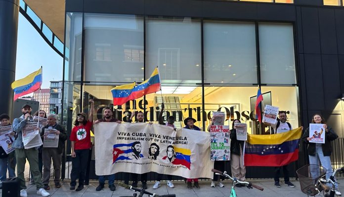 Protesters outside the London offices of the Guardian holding Venezuela flags and a banner reading 'Viva Cuba, Viva Venezuela, Imperialism out of Latin America'