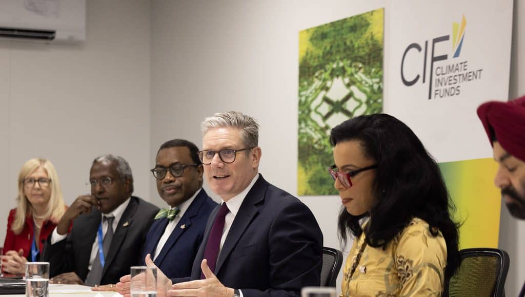 Prime Minister Keir Starmer at the COP29 conference in Azerbaijan (Photo: 10 Downing Street/Flickr). Starmer sits at a boardroom table talking and gesturing, with the logo 'Climate Investment Funds' on the wall behind him.