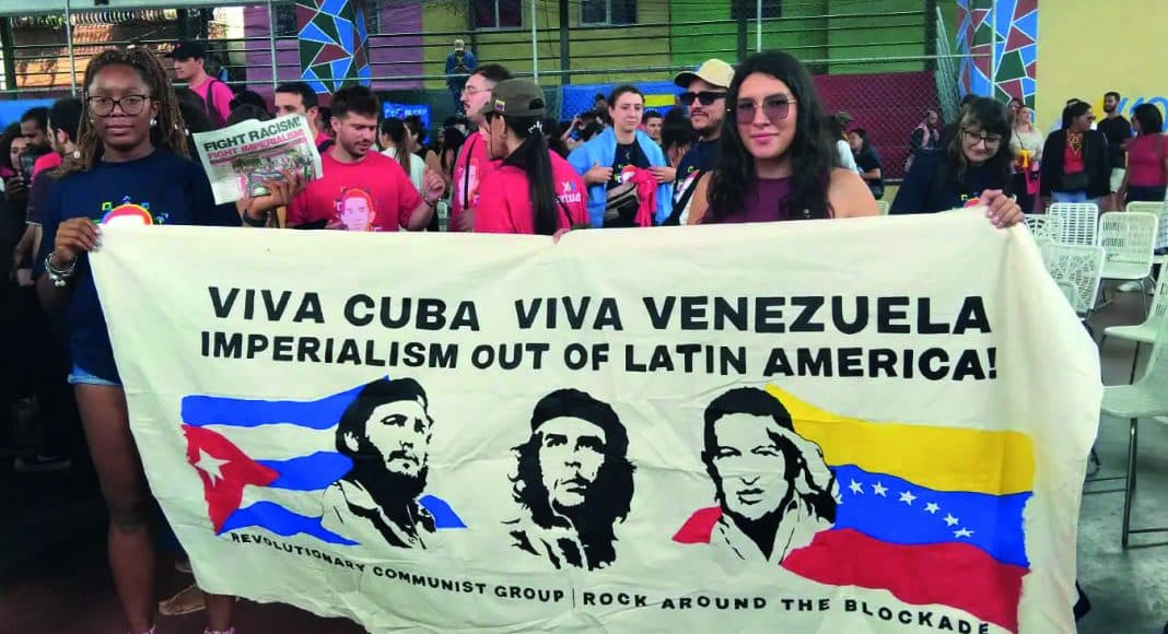RCG/FRFI banner held by comrades at the commune 'El Panal' in Caracas, Venezuela. Banner reads 'Viva Cuba, Viva Venezuela, Imperialism out of Latin America!' above images of Fidel, Che and Chavez.
