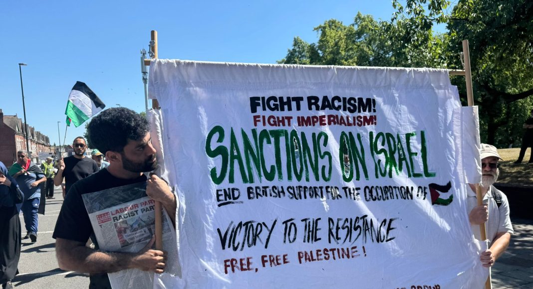 Birmingham FRFI supporters march with a banner demanding 'Sanctions on Israel' (photo: FRFI)