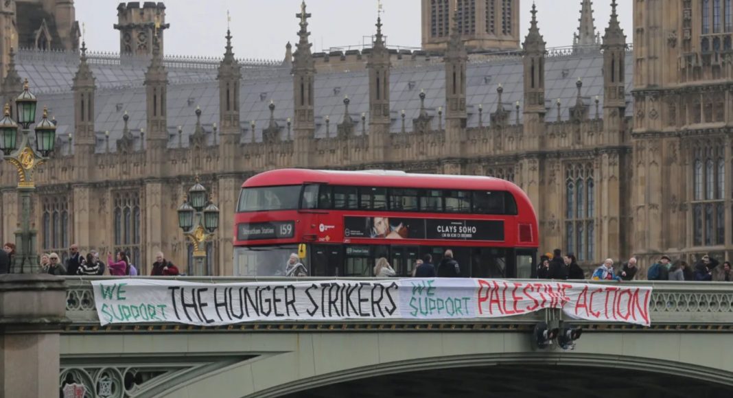 Protesters unfurl a banner in support of the hunger strikers on Westminster Bridge (photo: Prisoners For Palestine)