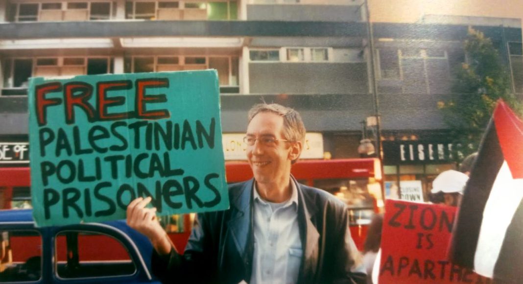 David Howarth holds a placard on a London street reading 'Free Palestinian political prisoners (photo: FRFI)