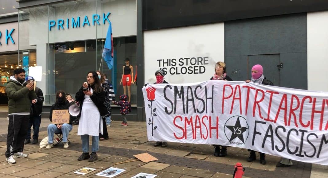 A woman speaks at a demonstration in honour of International Working Women's Day on a high street in Birmingham (photo: FRFI)