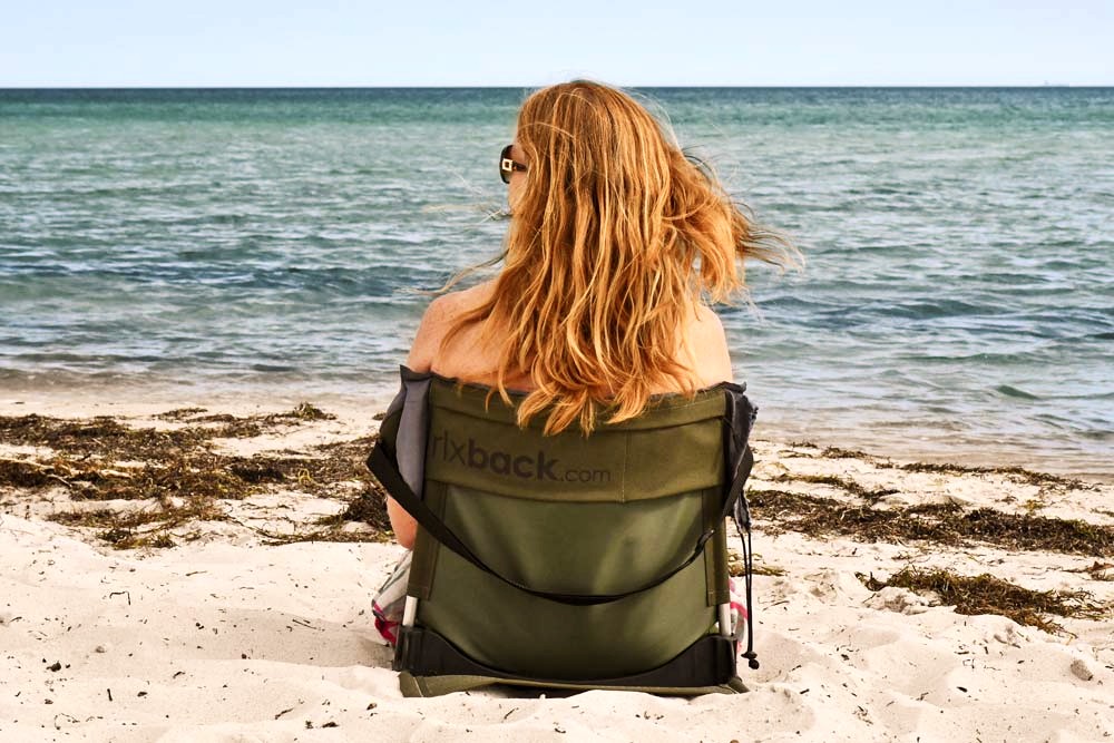 rlxback2 rlxback - en kvinna som sitter på en grön rlxback på en strand framför havet
