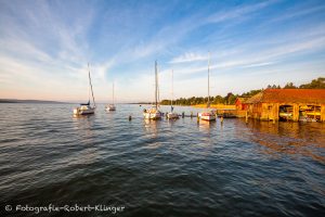 Ein Bootshaus und Segelboote auf dem Ammersee bei Schondorf