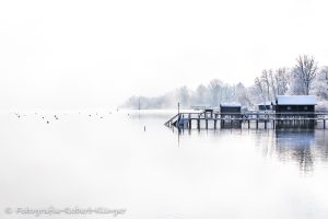 Verschneite Bootshäuser im Winter am Ammersee bei Holzhausen