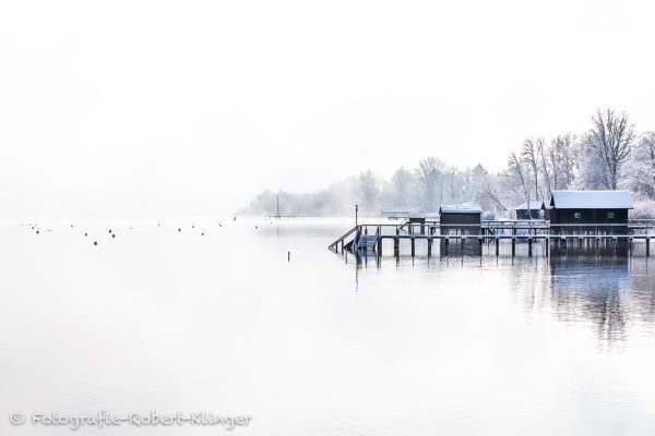 Verschneite Bootshäuser im Winter am Ammersee bei Holzhausen