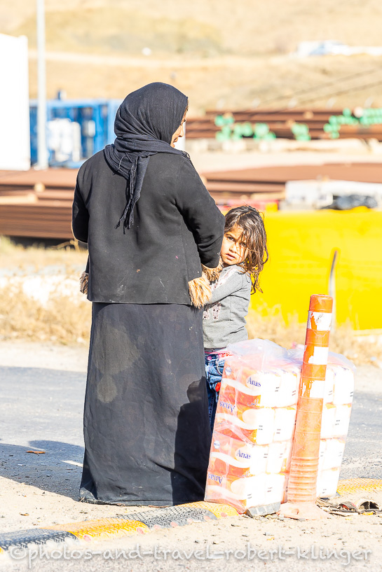 Eine Mutter verkauft mit Ihrer Tochter Waren direkt an der Straße im Irak