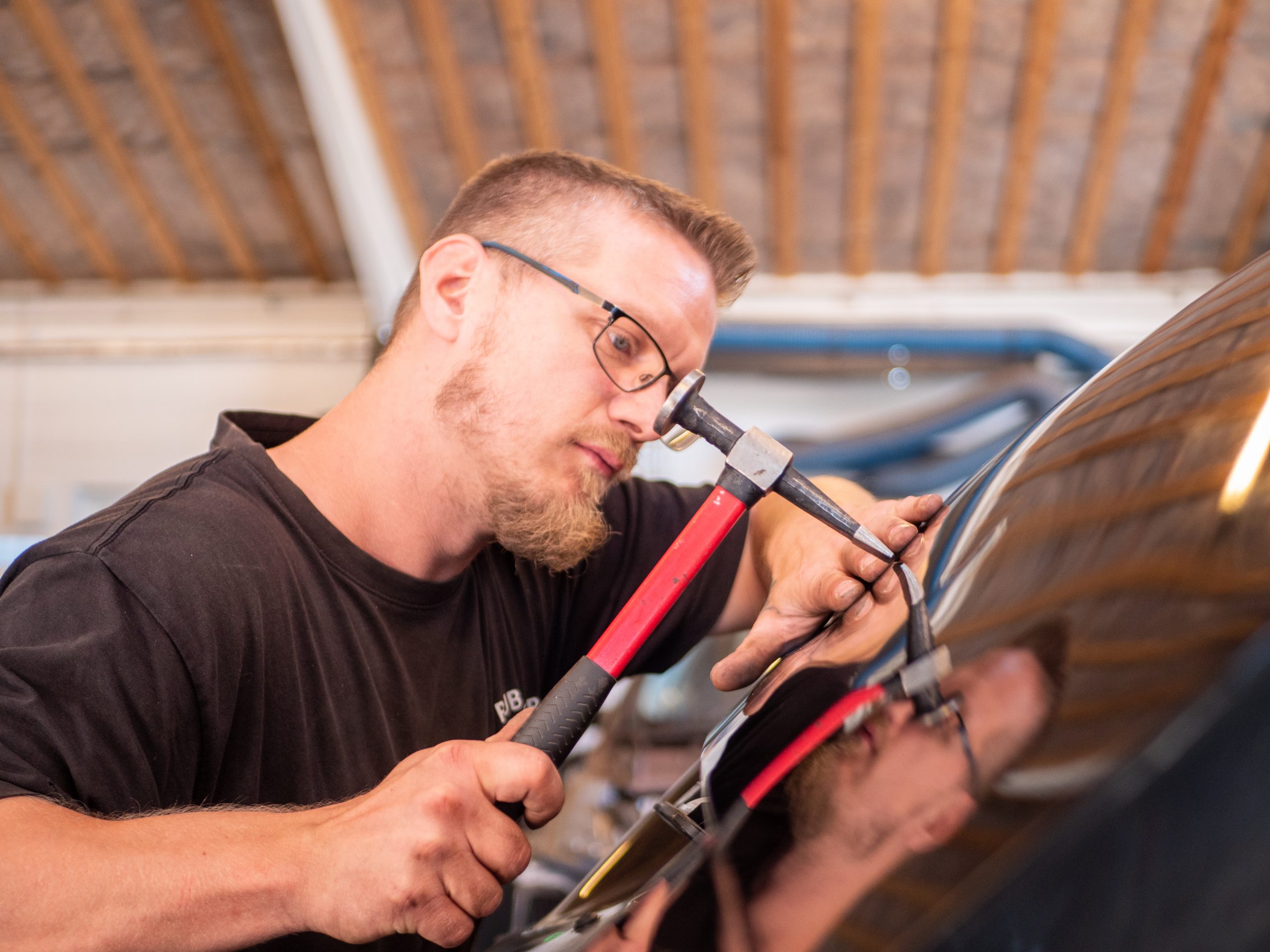 Karrossetekniker servicere en bilrude hos Rube Karrosseri