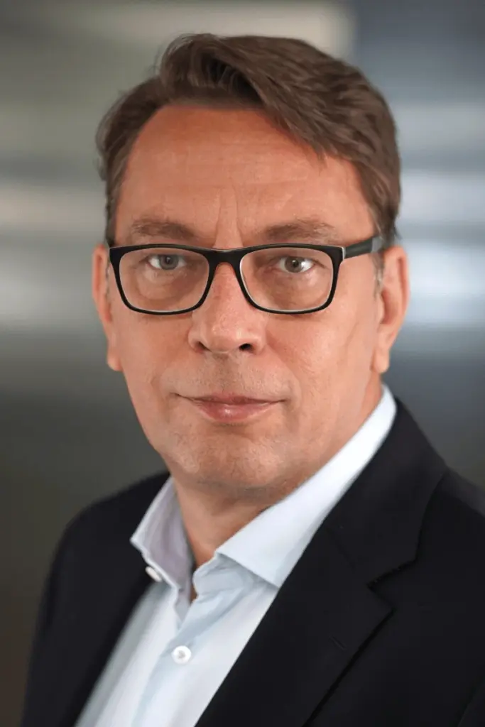 Stefan Rübener mit schwarzem Sakko und weißem Hemd