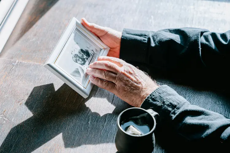 A man, looking at a photo of his loved ones.
