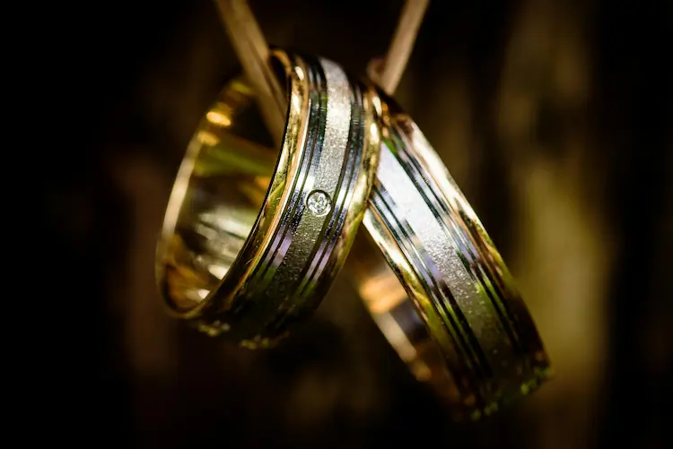 Two wedding rings, looped through a necklace strap.