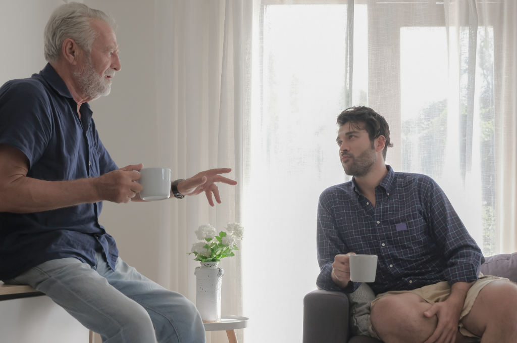 An older man and a younger man talking quietly at home