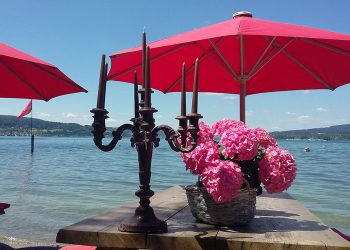 Tisch am See mit Blumen und Kerzenständer