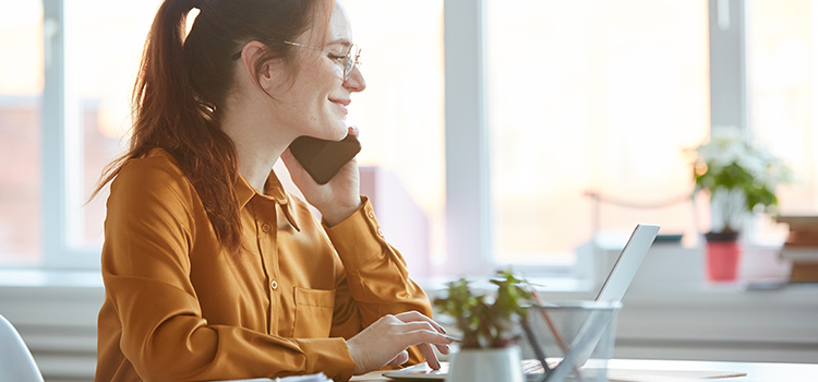 Frau die am Schreibtisch telefoniert 750x350 Web