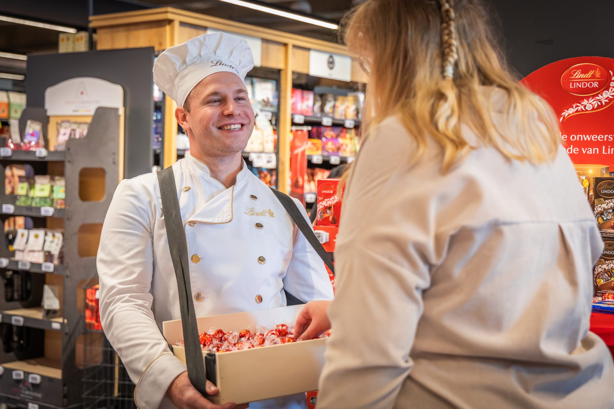 Man in baker's outfit handing out Lindt chocolates