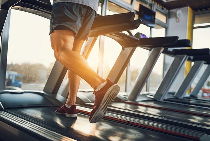 Un homme qui fait du cardio sur un tapis de course.