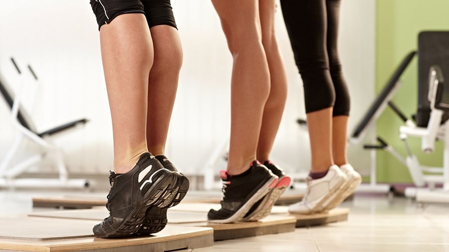 Several athletes performing extensions to build up their calves.