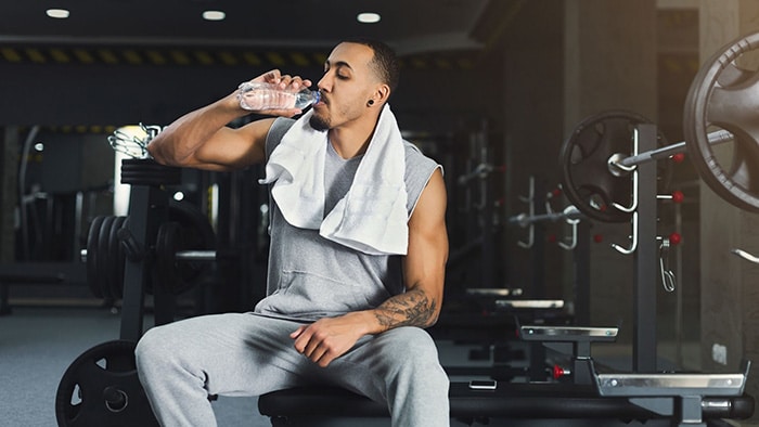 An athlete hydrates in the weight room