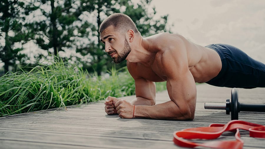 A muscular man performs a muscle-building exercise.