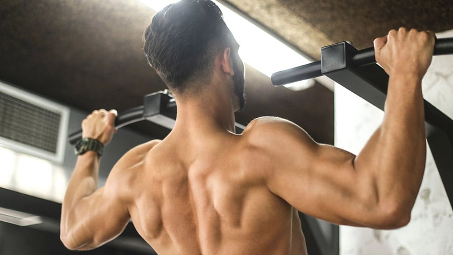 A man does a pull-up at the weight room.