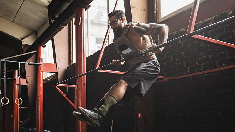 A man does a muscle up on the pull-up bar.