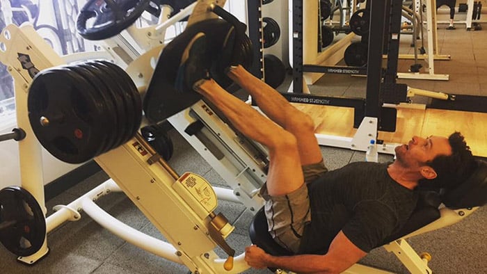 Hugh Jackman works out with a thigh press at the weight room.