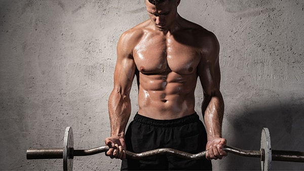 A man performs the biceps curl exercise with his shirt off.