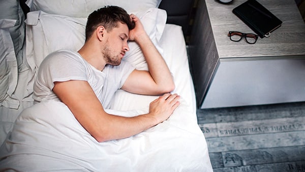 A man sleeping in his bed.