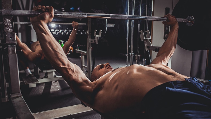 A man is training a bench press as part of a strength cycle.