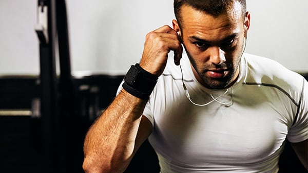 A sportsman puts on his headphones to listen to music.