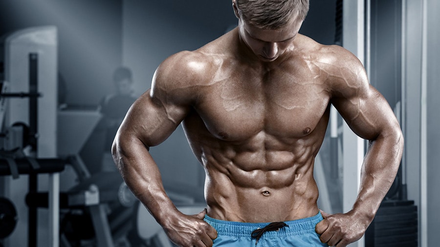 A shirtless bodybuilder, abs protruding, after a clean weight gain.