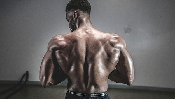 A shirtless man, from behind, with a muscular back.