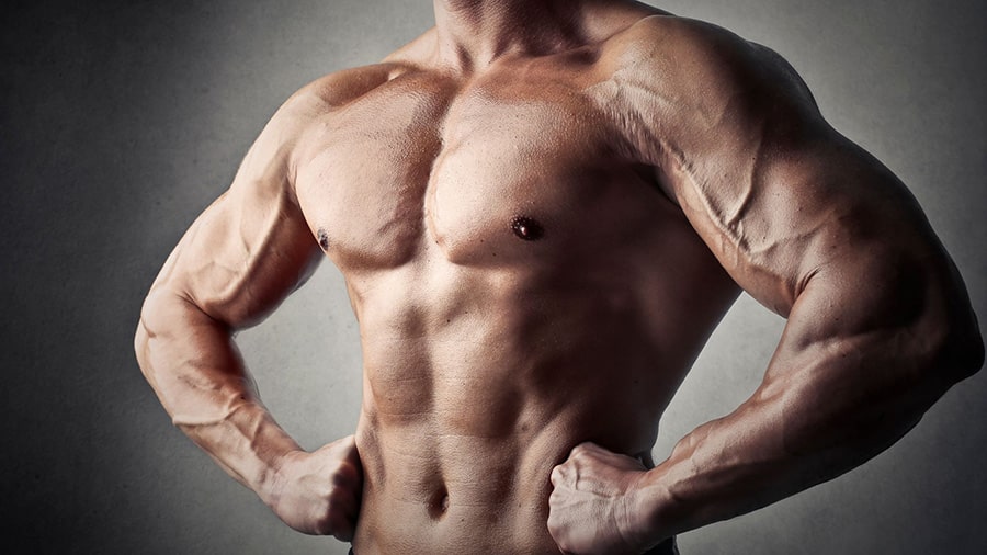 Un homme musclé torse nu, avec les ains sur les hanches.