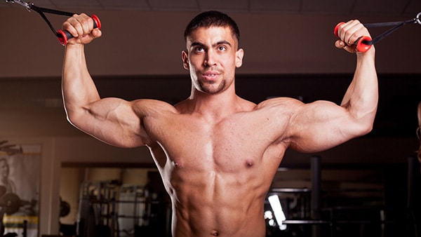 A torso man does a biceps exercise with a screw pulley in a gym.