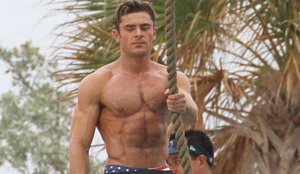 Zac Efron torse nu, les abdominaux apparents, dans le film Baywatch : Alerte à Malibu.