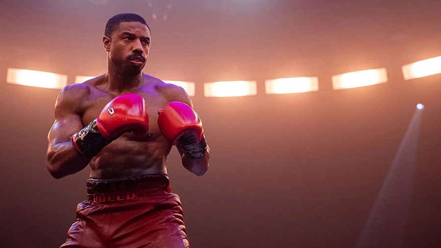 Michael B. Jordan as Adonis Creed, shirtless and ready to face his opponent in a boxing match.