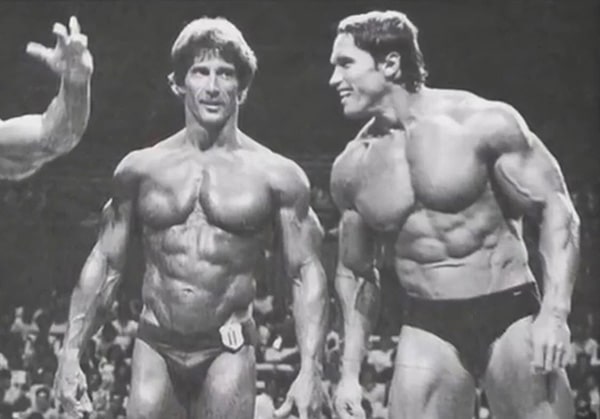 Frank Zane (left) and Arnold Schwarzenegger (right), both shirtless, at a bodybuilding competition.