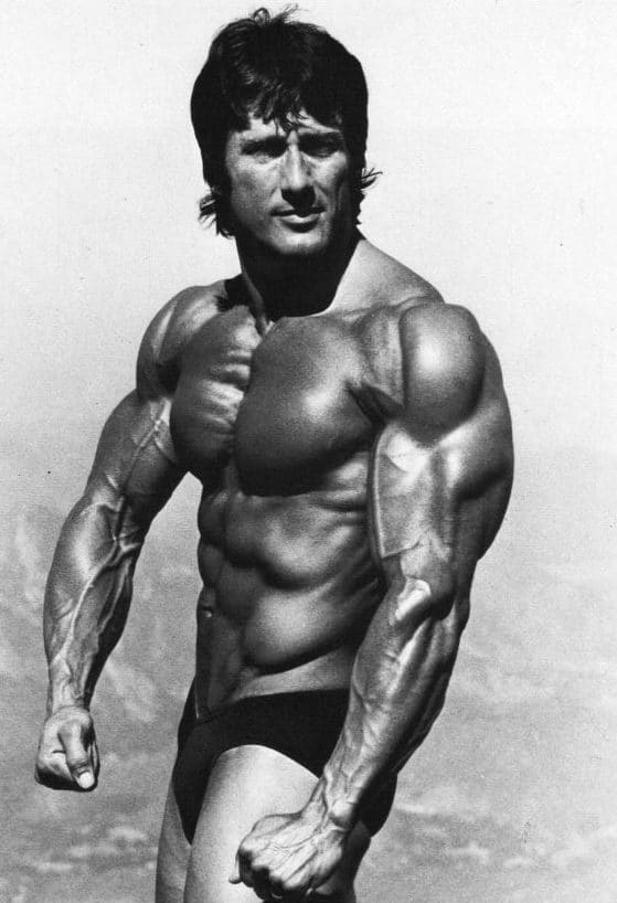 Shirtless bodybuilder Frank Zane during a posing session, muscles bulging.